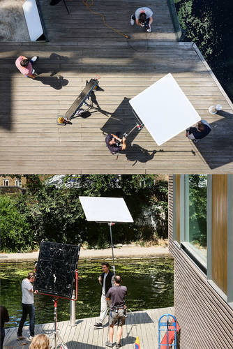 John MacLean Two and TwoDiptych showing a commercial photo shoot by Regent’s Canal. The upper image is taken from above, showing a photographer in a striped Breton top photographing a male model, with large white reflector boards positioned around them on a wooden walkway. The lower image is taken from the side, showing the same model demonstrating a vape beside the canal, flanked by oversized reflector boards and lighting equipment, with the photographer and crew visible. From the series Two and Two by John MacLean, demystifying the decisive moment.