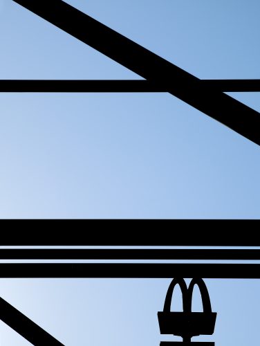 John MacLean A to Bwooden struts black against blue sky London Uk McDonald's sign silhouette