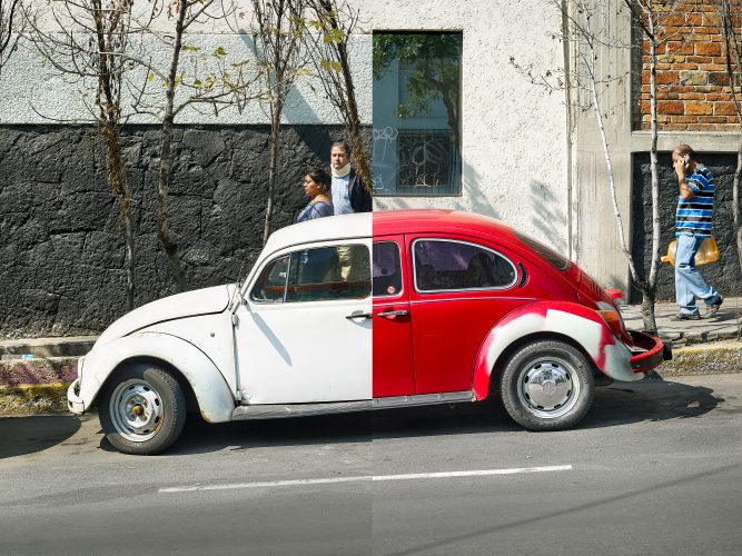 John MacLean HometownsTwo aging VW Beetles—one red, the other white—are parked along a road in San Ángel, Mexico City, Gabriel Orozco’s hometown. Twisted trees stand in the foreground, with a green and white gas station visible in the background. Both cars have been digitally altered in Photoshop, cut and joined together to mimic Gabriel Orozco’s iconic conceptual artwork La DS, serving as an artistic homage.