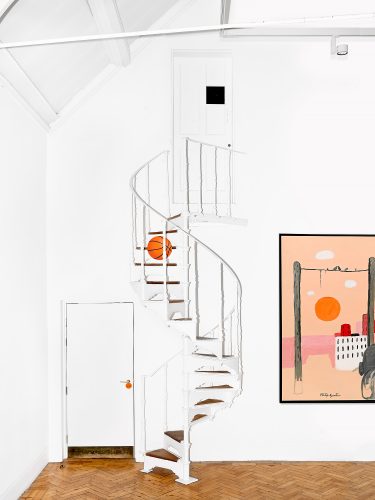 John MacLean ConversationsA flash-lit interior of Camden Arts Centre, London, UK, featuring Philip Guston’s painting of Klansmen in a car with an orange sun and birds on a wire. An emoji of a basketball is superimposed, bouncing down a spiral staircase in the scene, visually echoing the sun in Guston’s painting and adding a surreal, playful layer to the composition